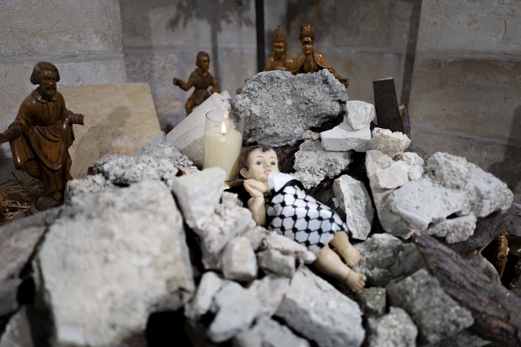 Nativity scene of Baby Jesus swaddled in a
    keffiyeh, buried in rubble